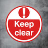 Keep clear red floor sign on grey industrial floor
